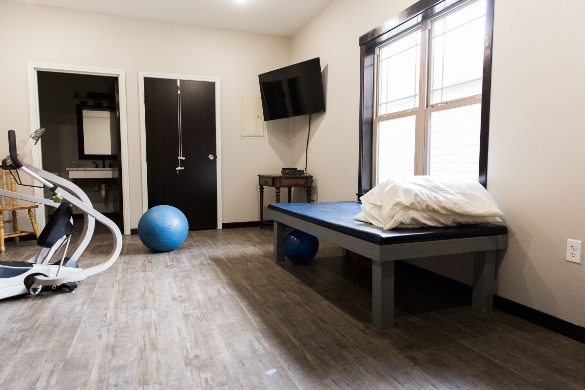 A physical therapy room equipped with an exercise ball and massage table.