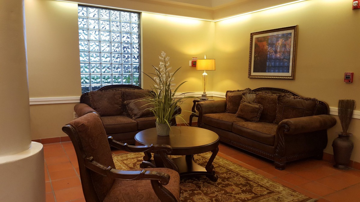 A cozy living room with comfortable sofas, a round table, and a warm lamp.
