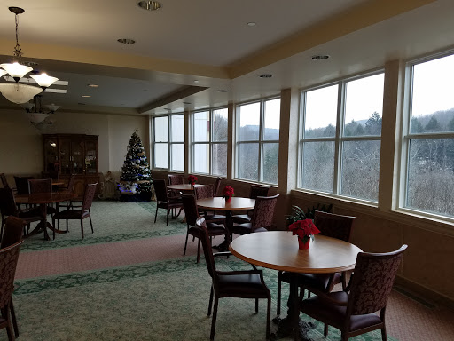 A spacious lobby area with tables and chairs, decorated for the holiday season.