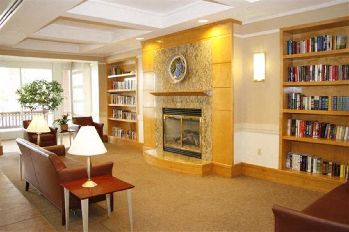 A cozy library interior with a fireplace and bookshelves.