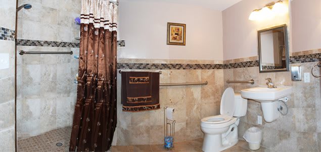 A cozy bathroom with decorative curtains and towel.
