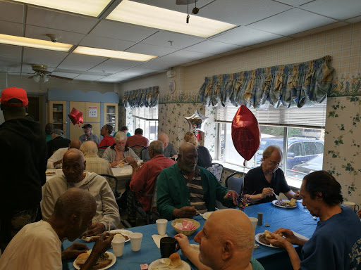 A lively social gathering of seniors enjoying lunch together at a community center.