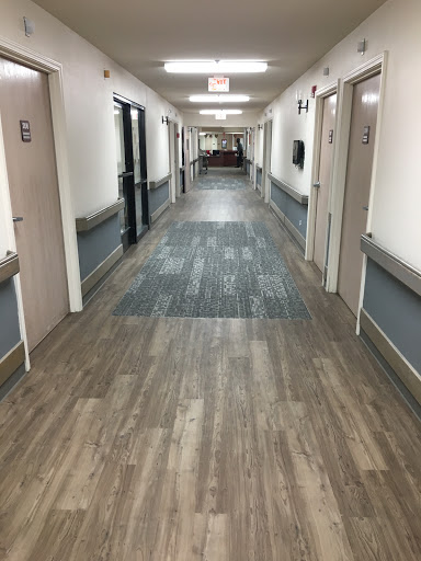 A long, well-lit hallway with multiple doors and modern flooring.