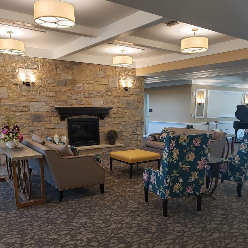 A cozy living room with a stone fireplace and comfortable seating arrangements.