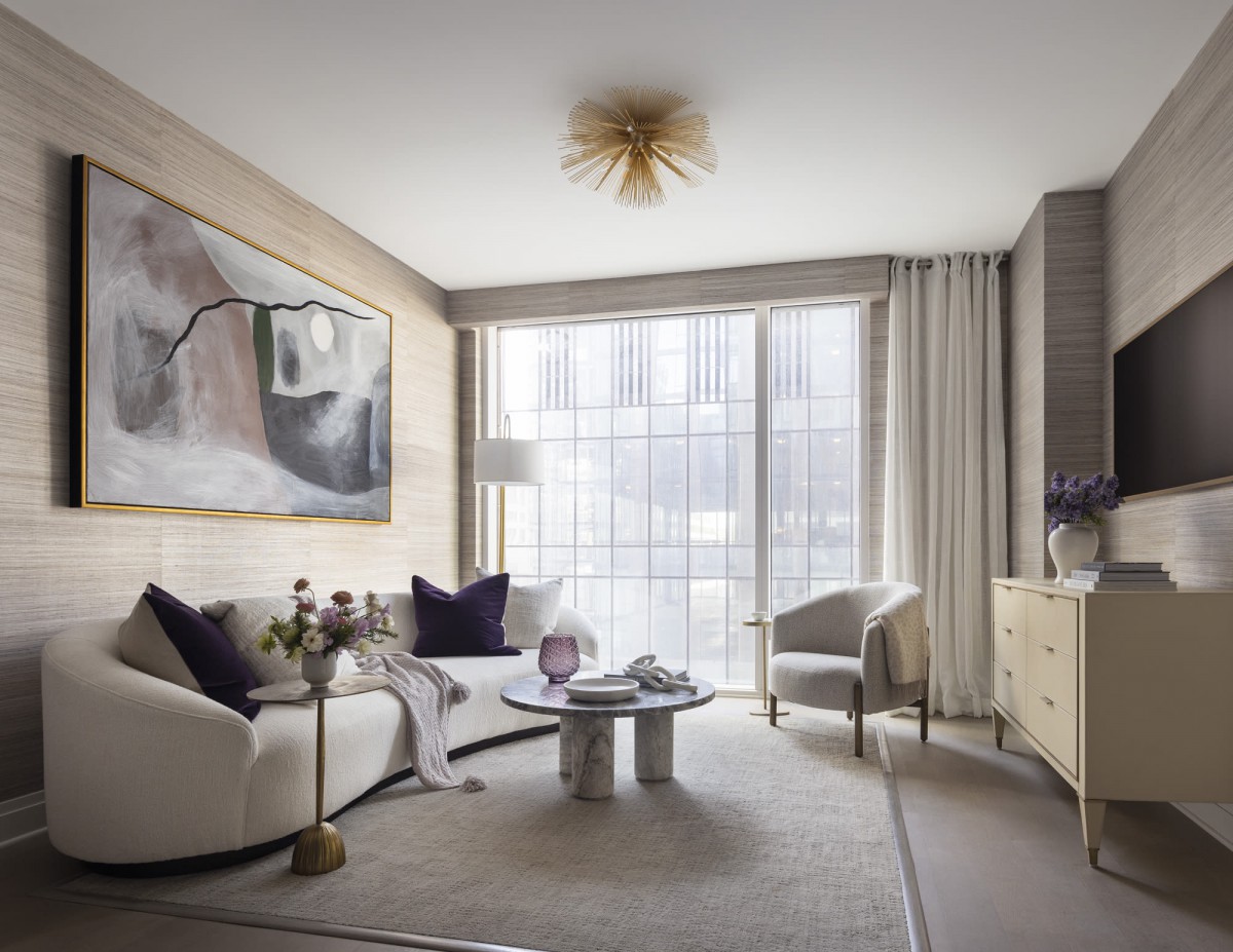 A modern living room with chic furniture and elegant decor, featuring a large window that lets in natural light.