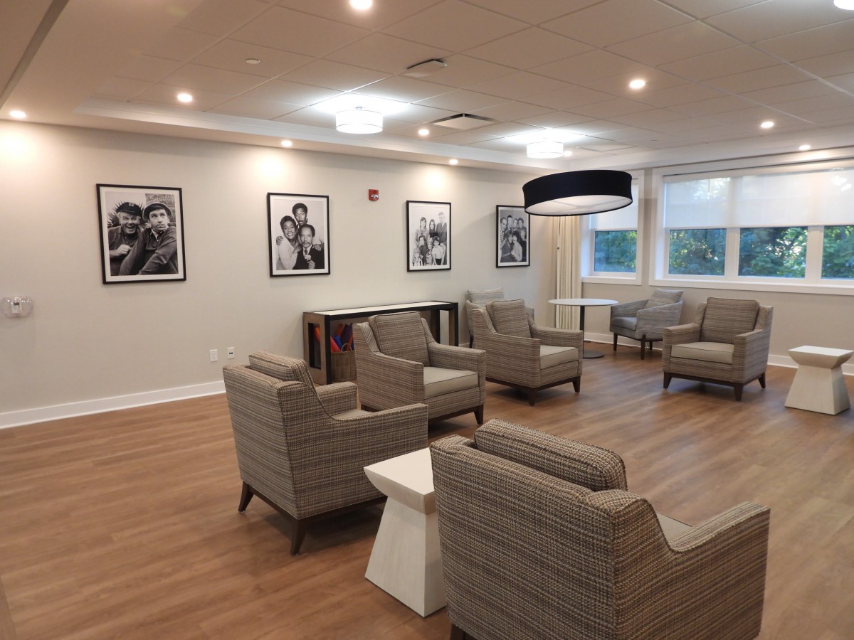 A modern lounge area with comfortable seating and framed artwork on the walls.