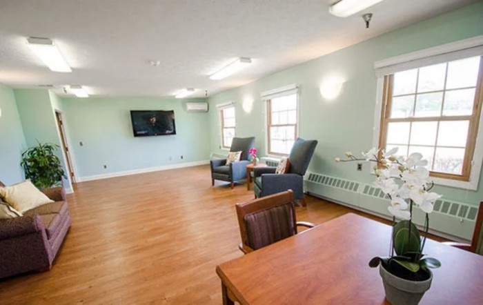 A bright and spacious living room with comfortable seating and a wall-mounted television.