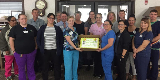 Healthcare team celebrating a special occasion with a cake.