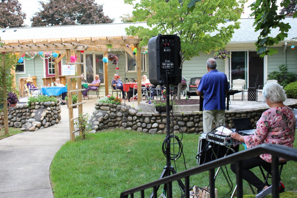 An outdoor gathering with music in a garden setting.