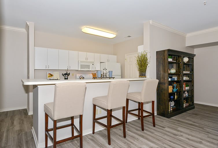 Modern kitchen with white cabinets and a breakfast bar featuring bar stools.