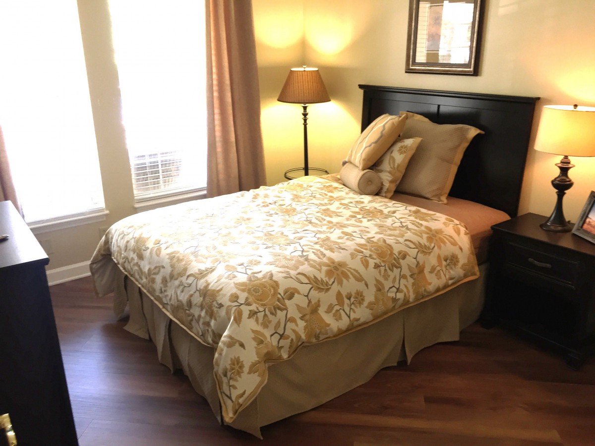 A cozy bedroom with a neatly made bed and warm lighting.