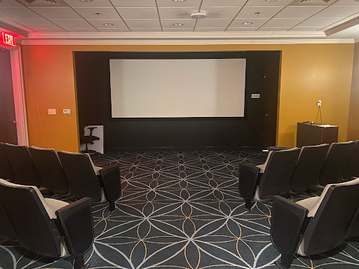 A modern cinema room featuring a screen and comfortable seating.