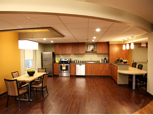 A modern kitchen featuring wooden cabinets, stainless steel appliances, and a spacious dining area.