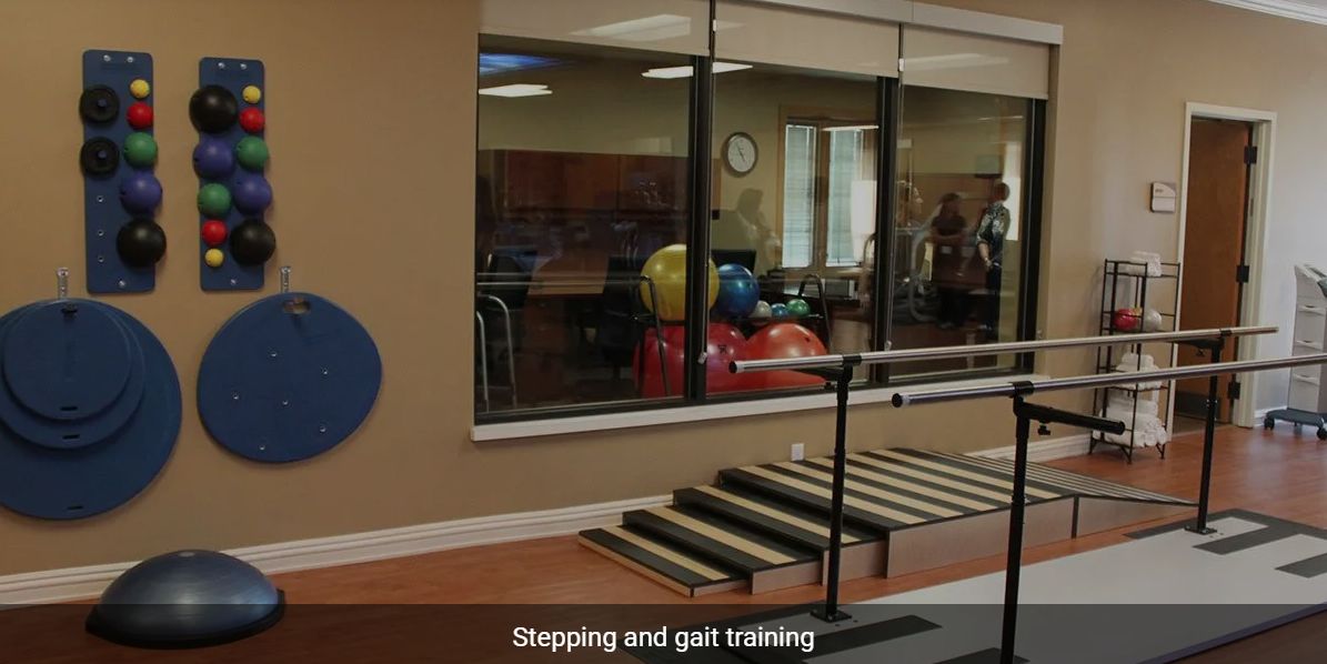 Physical therapy room with stepping and gait training equipment.