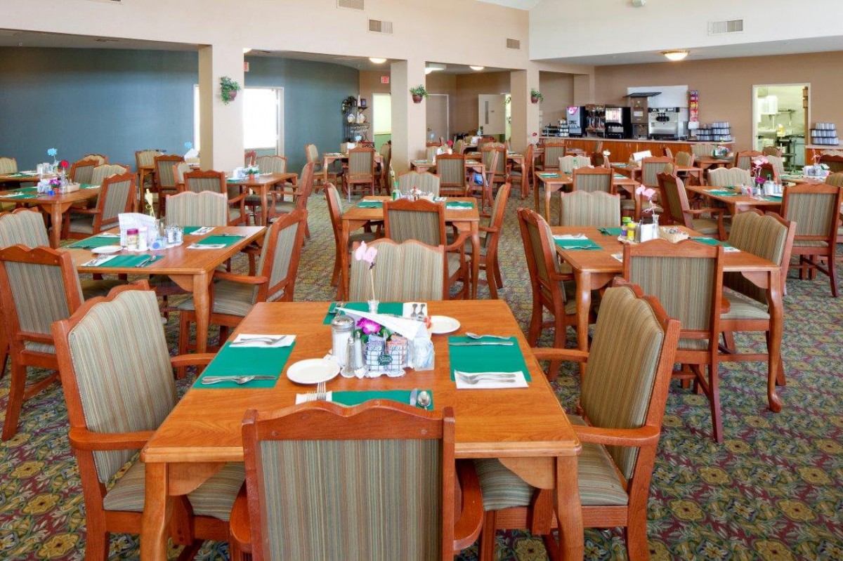 An empty dining area in a restaurant with neatly arranged tables and chairs.