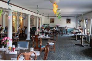 An elegant restaurant dining room with neatly arranged tables and chairs.
