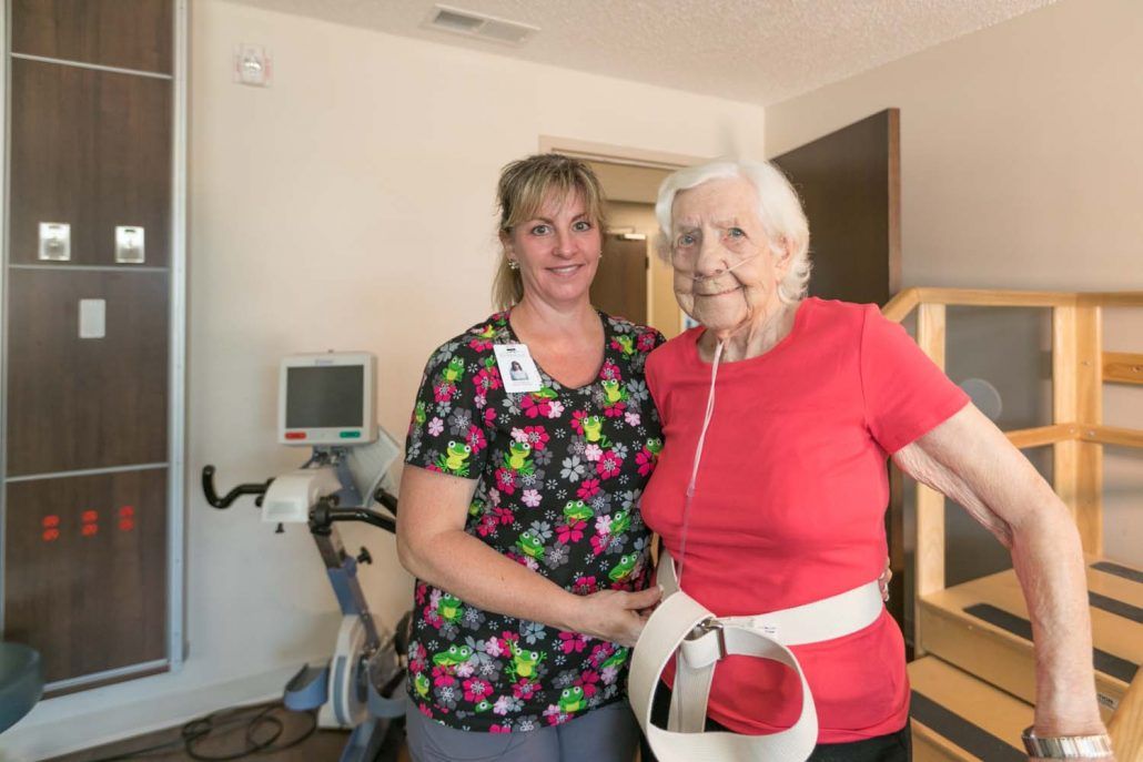 An elderly person with a caregiver in a healthcare setting.