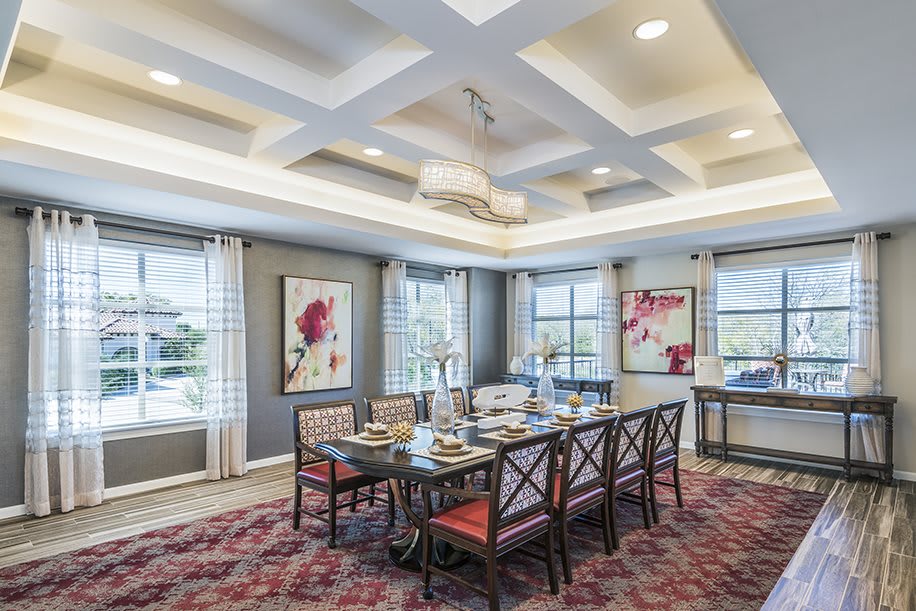 Elegant dining room with a large table, stylish chairs, and modern artwork.