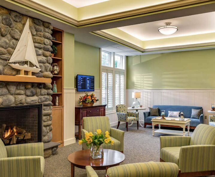 A cozy living room with a fireplace, comfortable seating, and green walls.