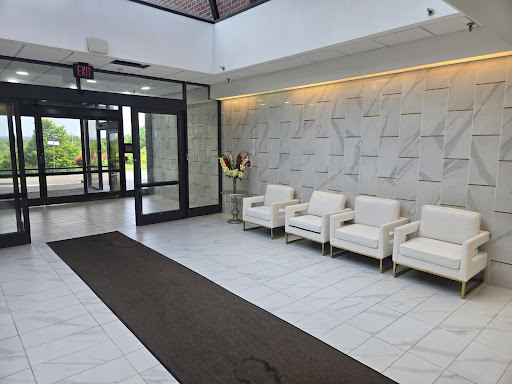 A spacious and modern lobby featuring white seating and elegant decor.