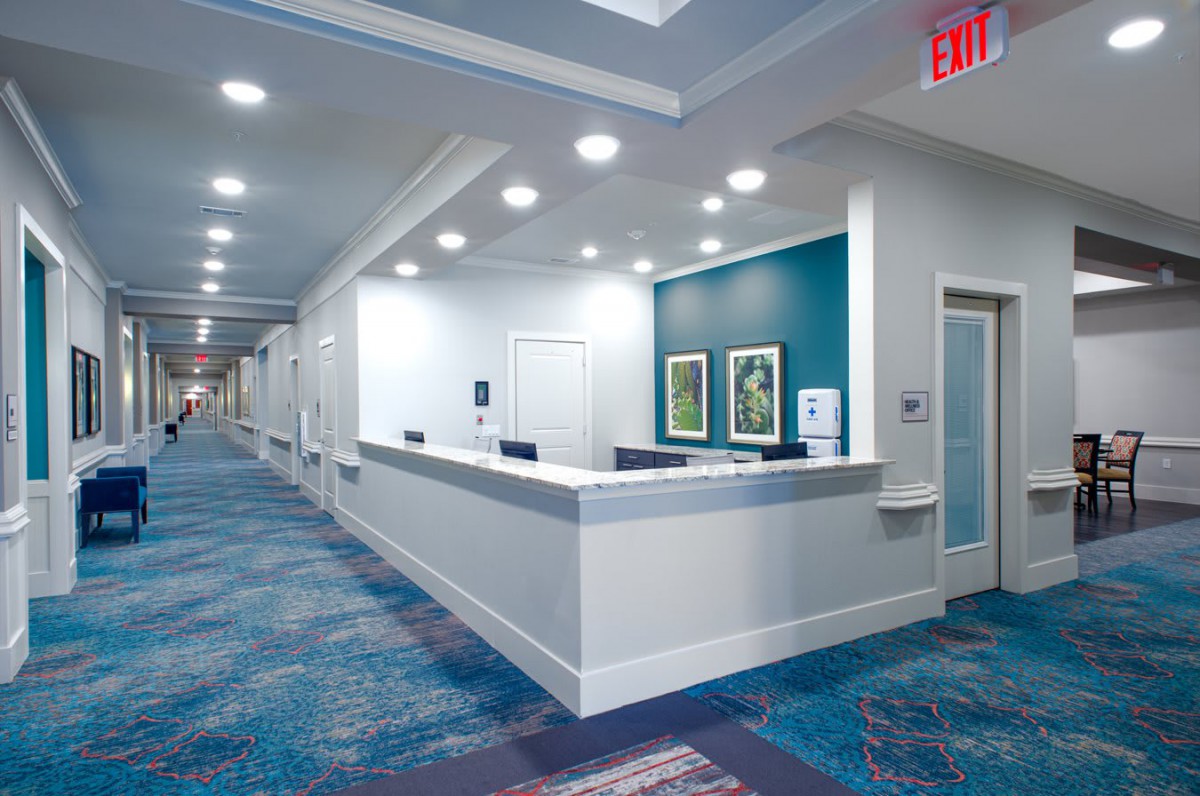 A modern reception area with a desk and hallway.