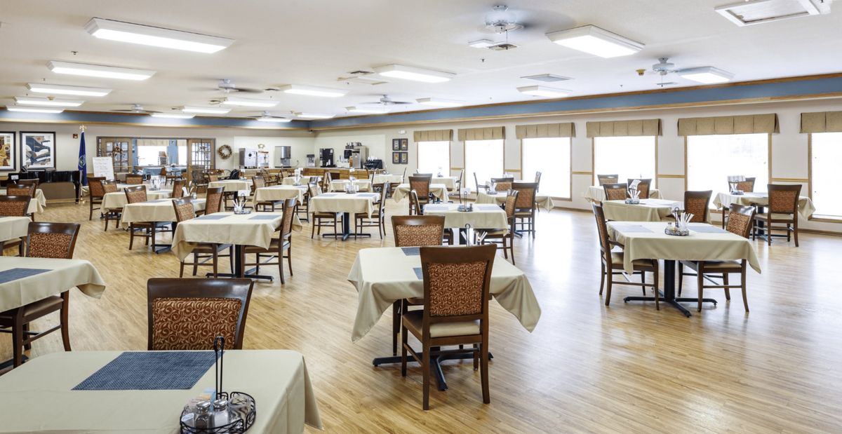 A spacious, well-lit dining area with neatly arranged tables and chairs.