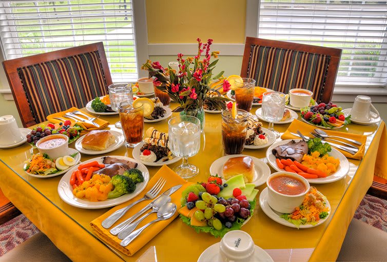A colorful breakfast spread with various dishes and drinks elegantly arranged on a dining table.