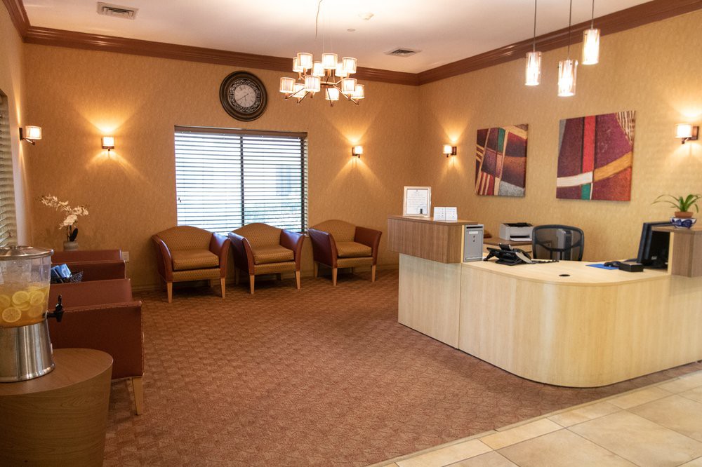 A well-lit waiting room with comfortable chairs and a reception desk.
