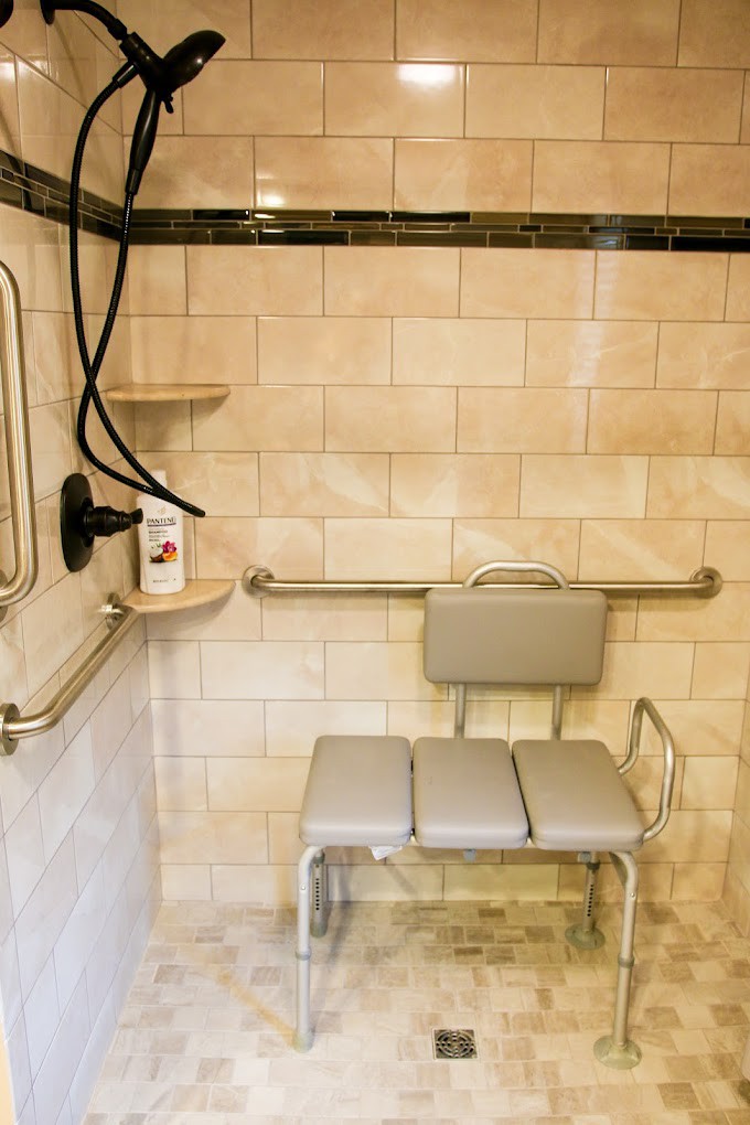An accessible shower equipped with a seat and grab bars for safety.