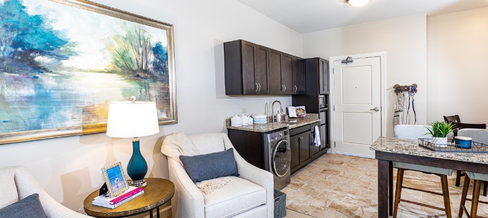 A cozy living space featuring a comfortable armchair, modern kitchenette, and stylish decor.