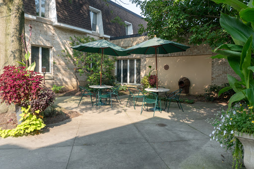 A peaceful outdoor patio area featuring tables with umbrellas, perfect for relaxation and enjoying the garden.