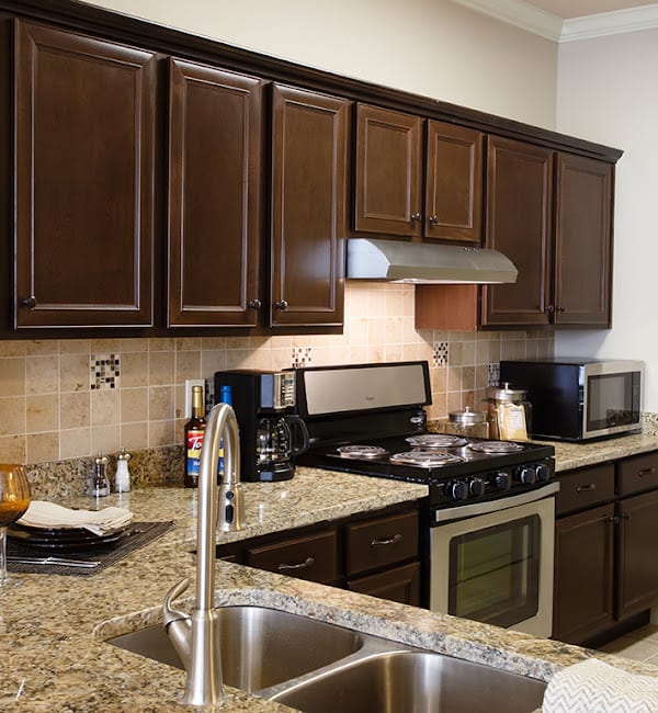 Modern kitchen with dark cabinets and granite countertops.