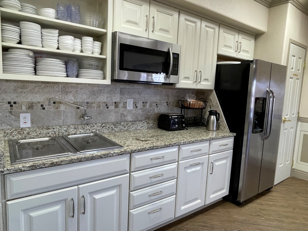 Modern kitchen with white cabinets and granite countertops.