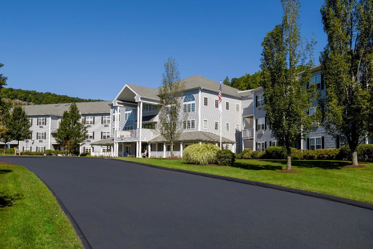 A large residential building with well-maintained landscaping and a wide driveway.