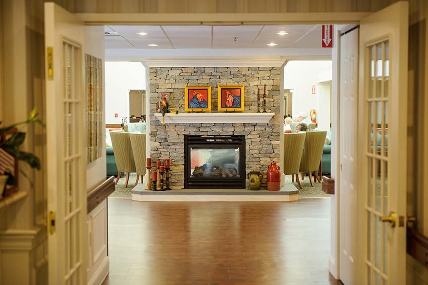 A cozy living room interior featuring a stone fireplace and comfortable seating.