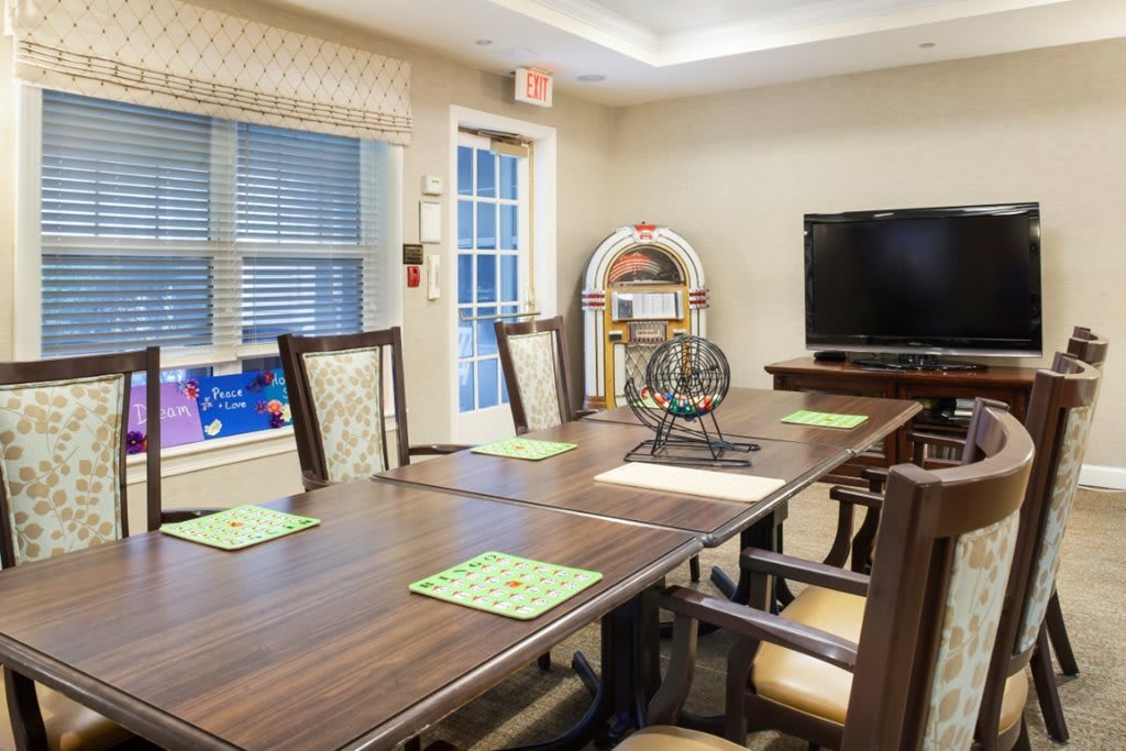 A meeting room featuring a large conference table, chairs, a television, and a bingo machine.