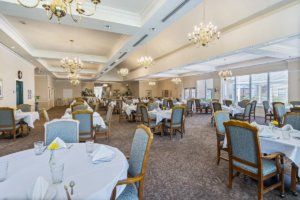 An elegant dining room with beautifully arranged tables and chandeliers.