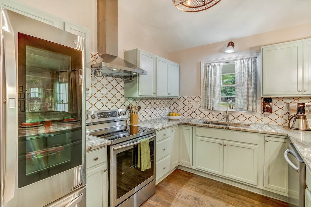 Modern kitchen with stainless steel appliances and stylish backsplash.