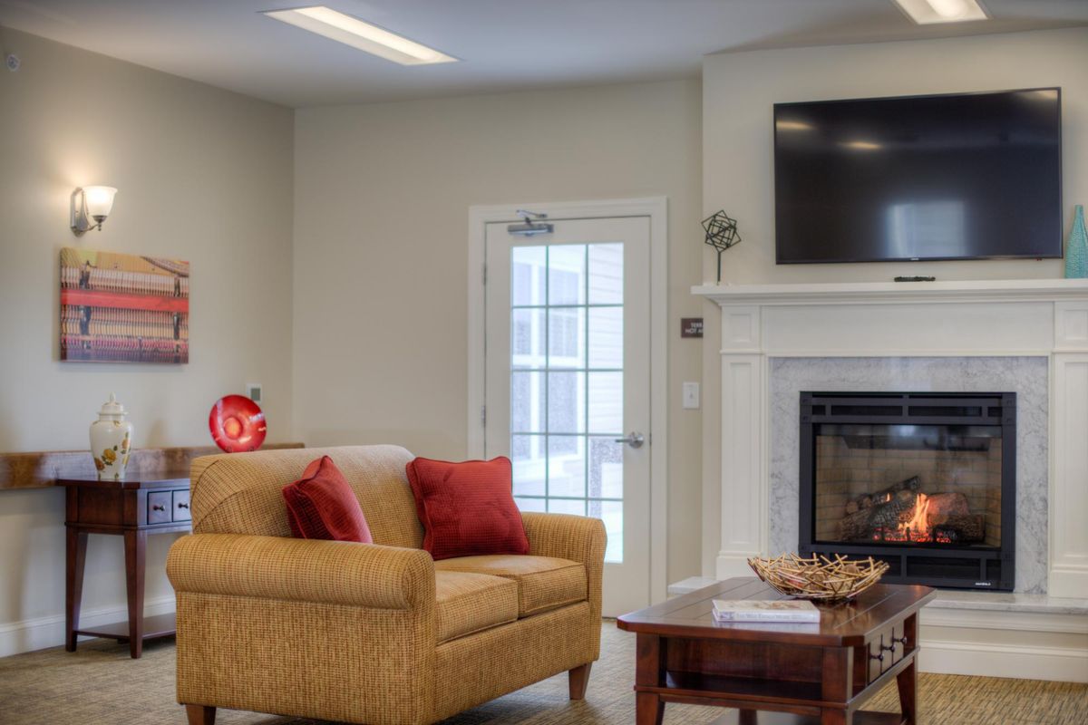 A cozy living room with a fireplace, sofa, and TV.