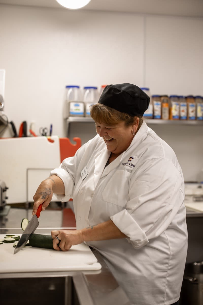 A chef chopping vegetables in a professional kitchen.
