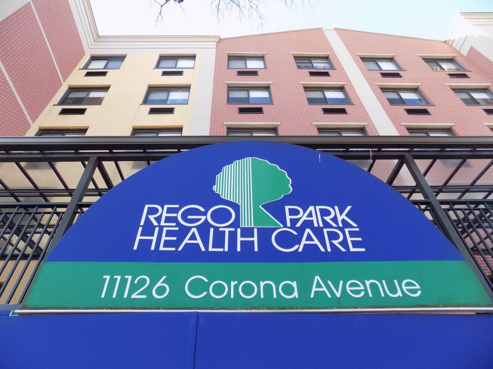 Entrance signage of Rego Park Health Care with building facade in the background.