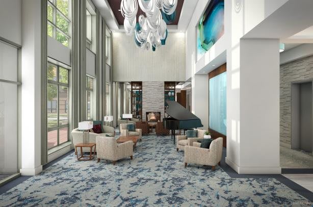 A modern lobby with high ceilings, contemporary furniture, and large windows.