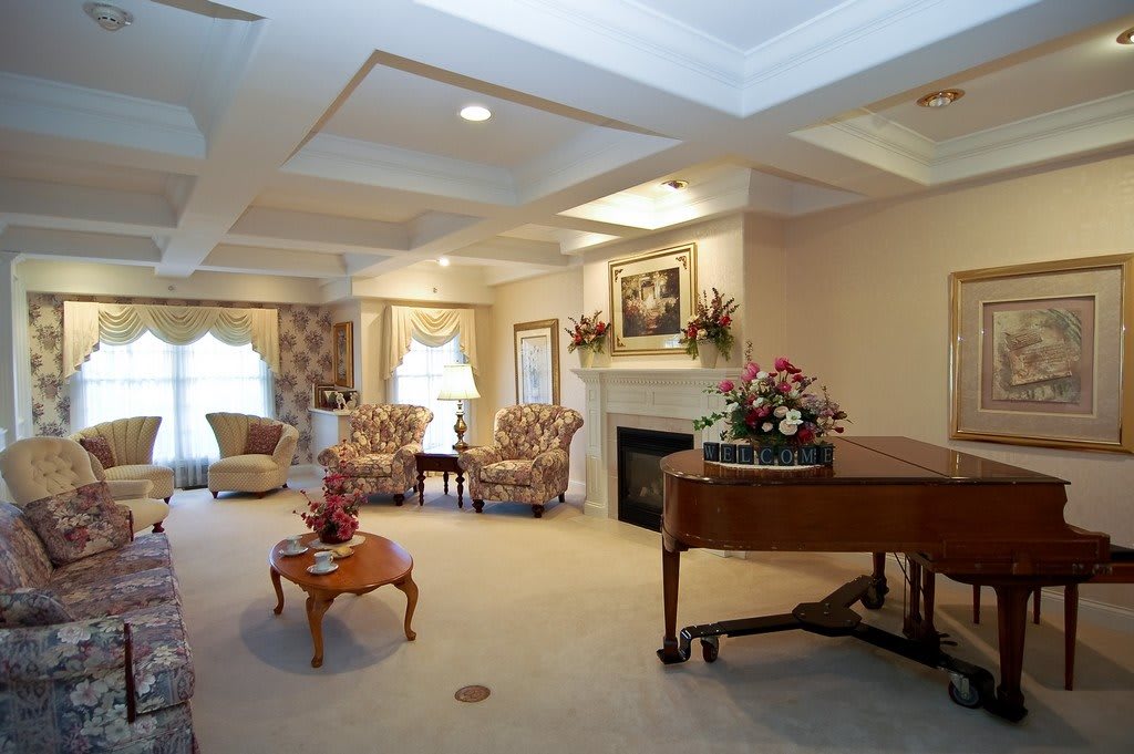 A traditionally decorated living room featuring elegant furniture and a grand piano.