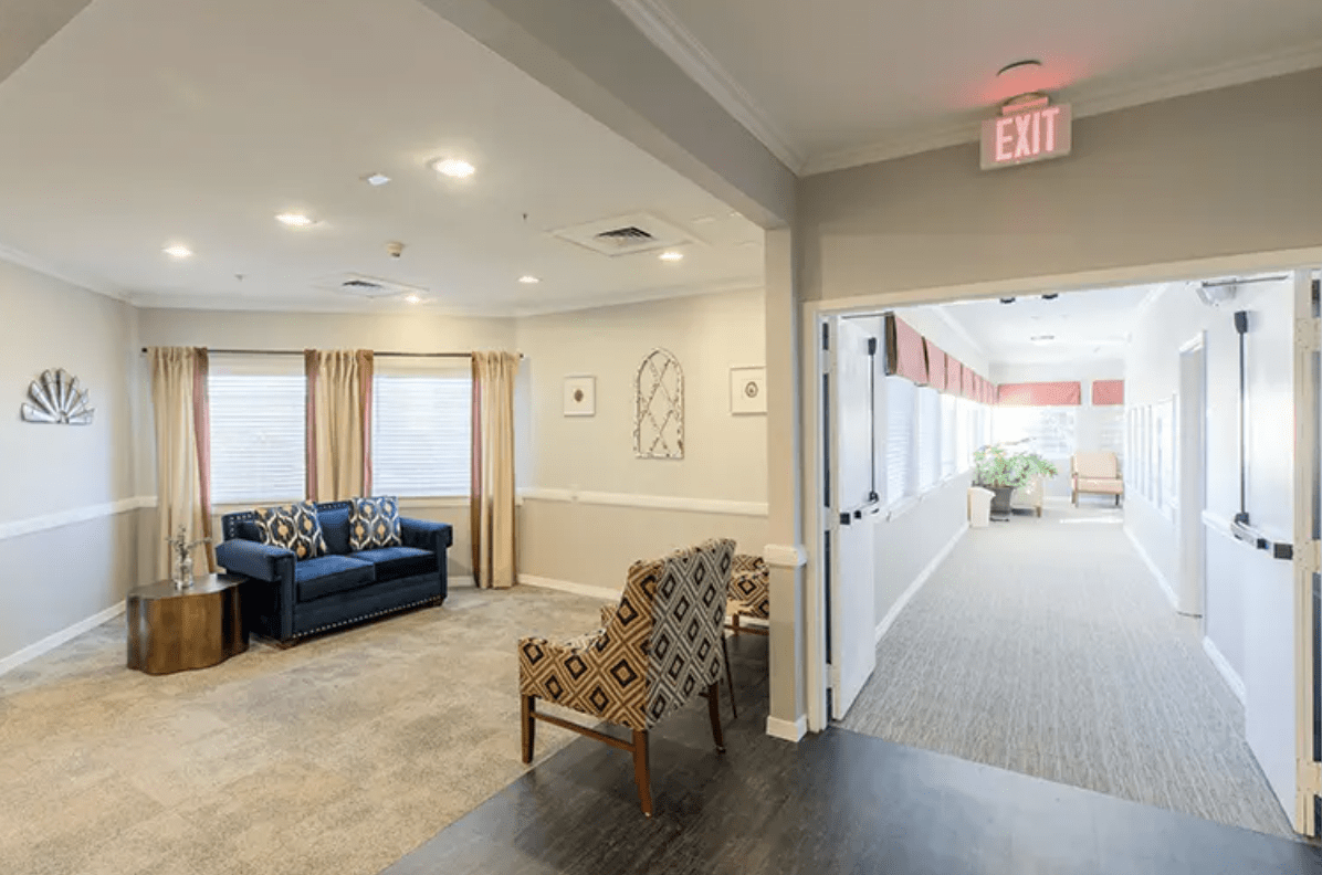 A cozy living room with a seating area adjacent to a well-lit hallway.