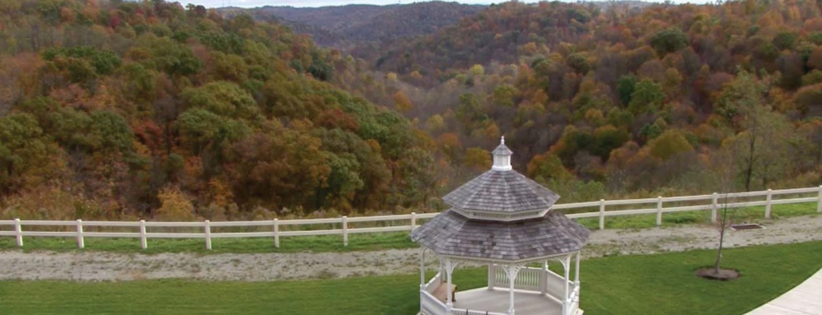 A scenic view of a gazebo overlooking autumn-colored hills.