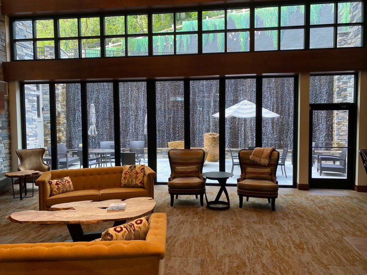 A cozy lounge area with large windows offering natural light and comfortable seating.