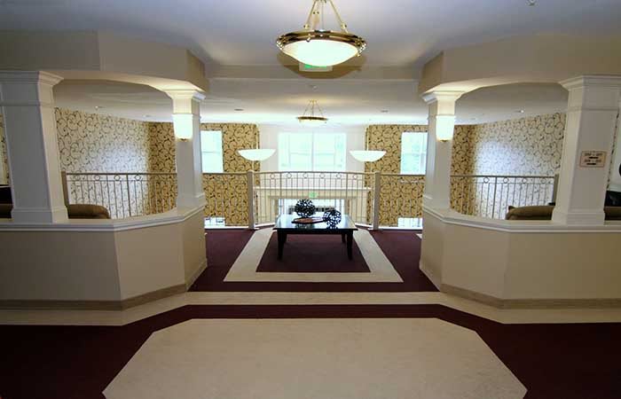 Elegant lobby with chandeliers and a balcony overlooking the space.