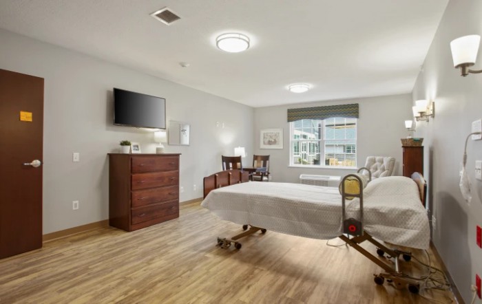 Modern and well-furnished hospital room with a single bed, television, and window.