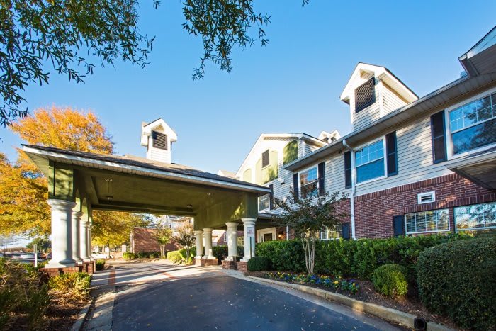 A residential building with a covered entrance and well-maintained landscaping.