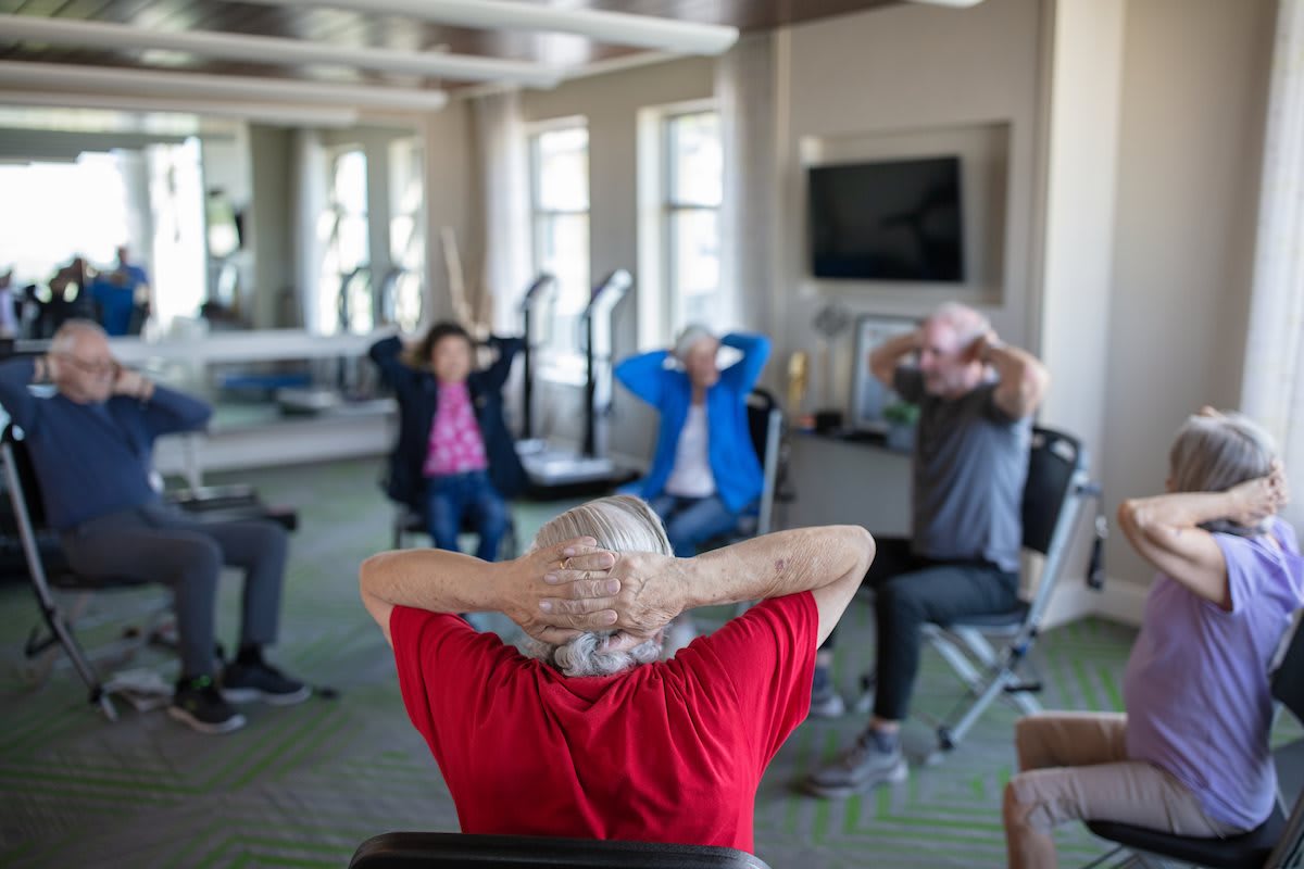 A group of seniors participating in a fitness class indoors.